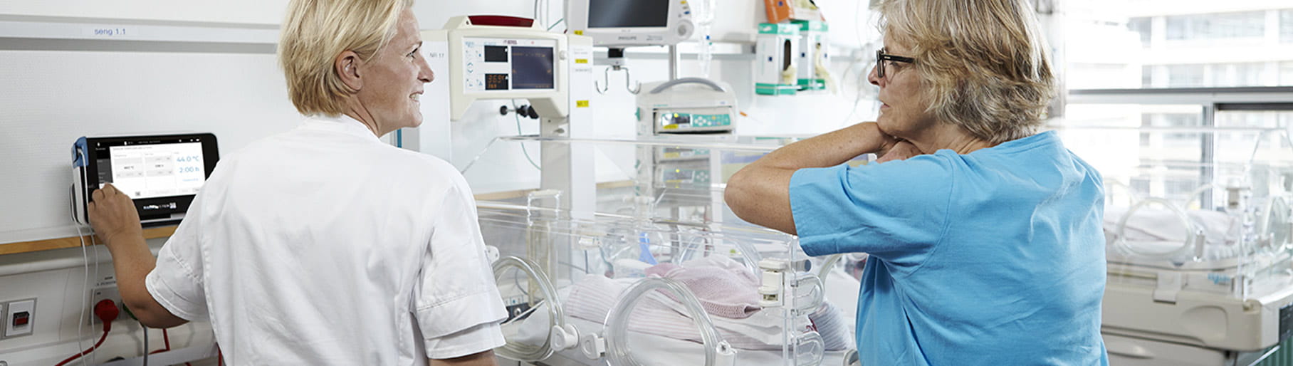 Situação hospitalar - duas enfermeiras da UCI neonatal a usar um monitor transcutâneo da Radiometer